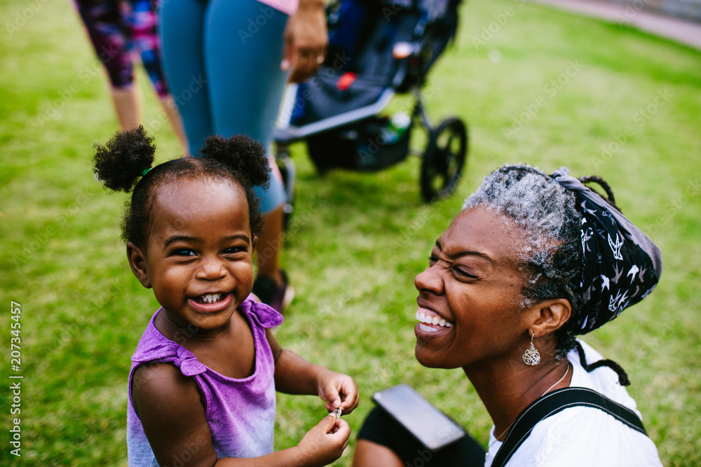 Smiling mother and daughter sitting in the park