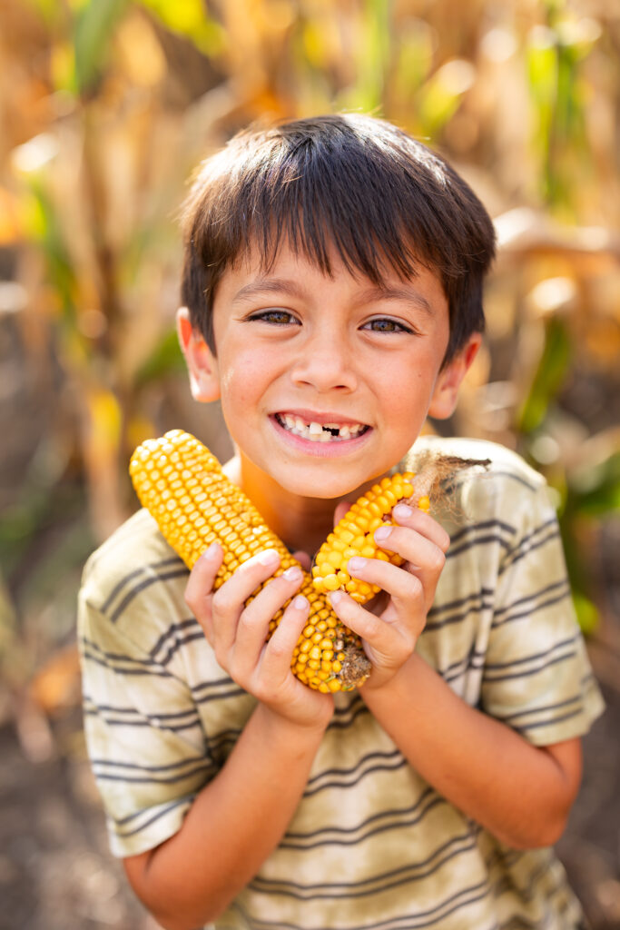 Boy holding corn in fall