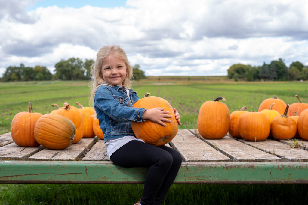 Little girl holding a pumpkin 