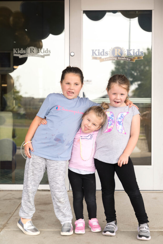 Kids 'R' Kids Family, three girls in front of the Childcare center.