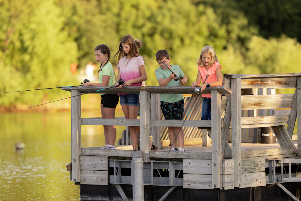 Kids fishing off the dock at the outdoor campus in Sioux Falls 