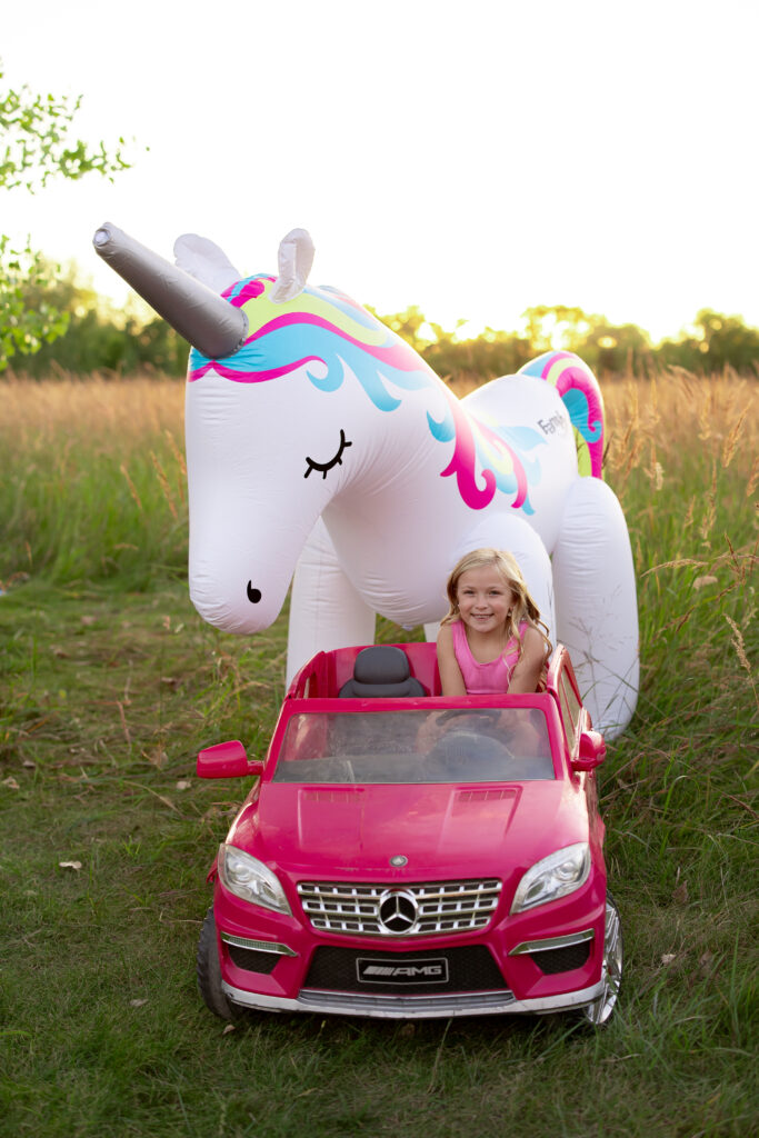 Bella sitting in the pink car with fancy in the background