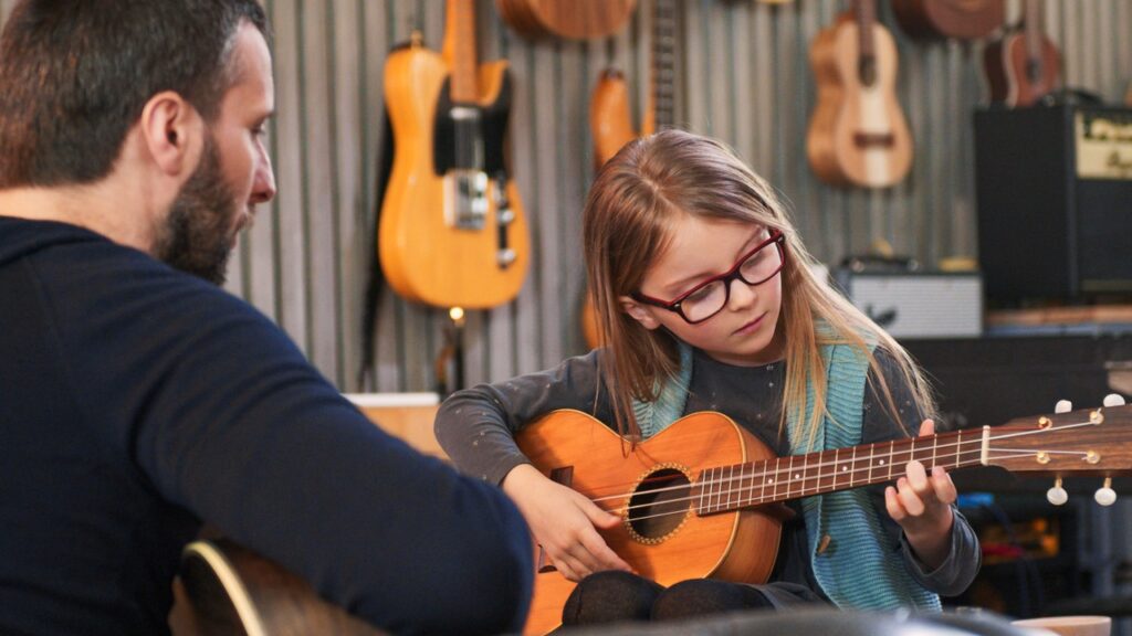 Girl learning how to play guitar